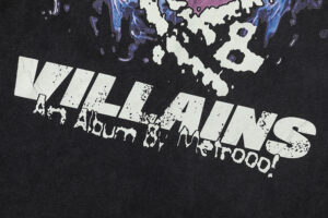 Detailed close-up of the Hellstar Heroes Villains t-shirt featuring the distressed graphic text on black fabric.