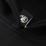 Close-up of the official Hellstar brand neck label on a premium black cotton-blend pullover graphic logo hoodie.