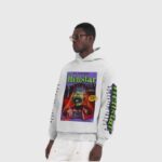 Model wearing a white Hellstar Horror Book graphic hoodie with screen print design and drawstring hood.