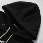 Close-up view of the premium black Hellstar Hstar tracksuit hoodie featuring a detailed brand tag and drawstrings.