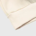 Close-up view of the ribbed knit cuff and premium cotton fabric on the Hellstar HStar Records Hoodie in cream color.