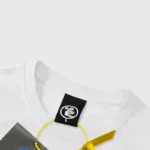 Close up of the Hellstar HStar Retro T-Shirt neck label on a white cotton crew neck tee with product tag attached.