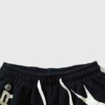 Close-up view of the elastic waistband and white drawstring detail on black Hellstar Hstar shorts for men and women.