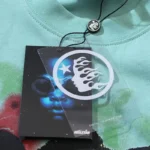 Official Hellstar Human Skeleton T-Shirt featuring brand clothing tag with logo details on light blue cotton fabric.