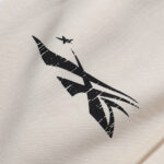 Detailed close-up of the Hellstar logo graphic printed on the premium cream-colored heavyweight fleece sweatpants.