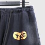 Hellstar If You Don't Like Us Beat Us black sweatpants featuring a distressed vintage effect and orange graphic print.