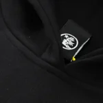Close-up view of the interior neck label detail on the black Hellstar Inner Peace Fire hoodie, showing brand branding.