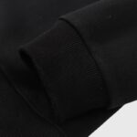 Close-up view of the ribbed sleeve cuff detail on the premium black Hellstar Jesus Wings fleece pullover hoodie.