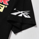 Close-up view of the sleeve graphic detail on a black Hellstar Knock Out T-Shirt featuring a white logo design.