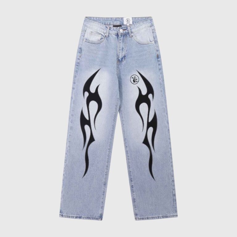 Hellstar light wash denim jeans with black flame graphics on the front in a streetwear style against a gray background.