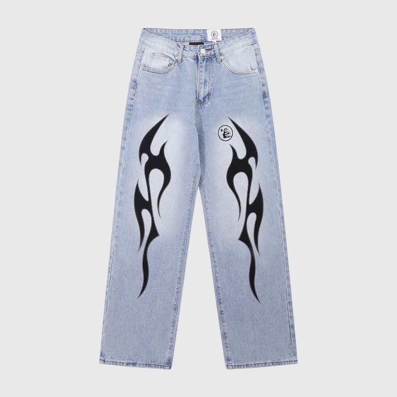 Hellstar Light Wash Flame Jeans Front View Hellstar light wash denim jeans with black flame graphics on the front in a streetwear style against a gray background.
