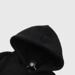 Close-up view of a premium black Hellstar logo print hoodie, highlighting the hood detail and branded interior tag.