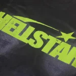 Detailed view of the Hellstar Marble Classic T-Shirt featuring a vibrant distressed neon graphic print on black fabric.