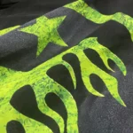 Close-up view of the unique bright green marble graphic print on the premium black Hellstar classic cotton t-shirt.