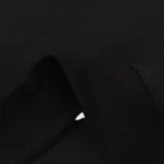 Close-up view of the premium black cotton fleece fabric texture used for the Hellstar Mask Print streetwear hoodie.