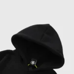 Close-up view of the black Hellstar Mask Print Hoodie showing the hood detail and branded inner tag for streetwear.