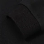 Close up view of the black ribbed sleeve cuff on the Hellstar Mask Print streetwear hoodie for men and women.