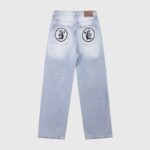 Hellstar men's light blue graphic denim jeans featuring circular logos on the back pockets and signature branding.