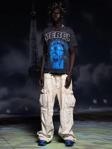 Model wearing a black Hellstar Mercy graphic t-shirt and white cargo pants against a dark Parisian background