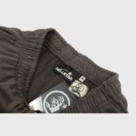 Detail view of the inside label and branding on a pair of grey Hellstar Mirror Faced sweatpants with a tag.