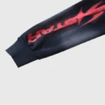 Close-up view of the sleeve on the Hellstar Motion Blur Tracksuit featuring a red graphic print on black fabric.