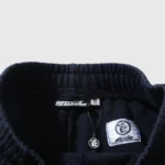 Detail of the elastic waistband and branded tags on a black Hellstar Motion Blur tracksuit sweatpants pair.