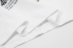Close up view of the premium white cotton fabric and graphic screen print details on the Hellstar Breaking News T-shirt.