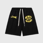 Front view of Hellstar No Guts No Glory black streetwear shorts featuring yellow graphic prints and drawstring waist.