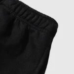 Close-up view of the elastic waistband on the premium black Hellstar No Guts No Glory streetwear fleece shorts.