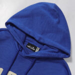 The blue Hellstar No Guts No Glory hoodie showing the interior brand neck tag and drawstring hood detail.