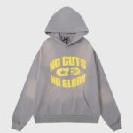 Hellstar No Guts No Glory hoodie in grey featuring yellow graphic lettering and a vintage washed aesthetic design.