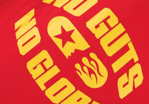 Close-up graphic detail of the red Hellstar No Guts No Glory t-shirt featuring yellow vintage screen-printed lettering.