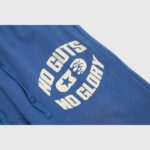 Close-up view of the Hellstar No Guts No Glory sweatpants in blue with a distressed graphic print on the fleece fabric.