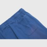 Close-up view of the blue pocket detail on the vintage washed Hellstar No Guts No Glory sweatpants with elastic waist.