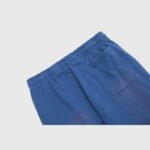 A close-up view of the rear pocket and elastic waistband on Hellstar No Guts No Glory blue vintage-washed sweatpants.