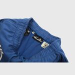 Close-up of the internal waist label and branding on the blue Hellstar No Guts No Glory sweatpants with drawstring.