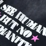 Close-up view of the bold white No Humanity graphic screen print on black premium cotton Hellstar athletic shorts.