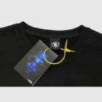 Detail shot of the Hellstar P2P T-Shirt in black showing the premium brand neck tag and attached product hang tag.