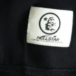 Close-up of the Hellstar Paradise Girls T-shirt authentication tag featuring the brand logo and NFC scan area.