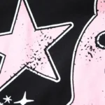 Close-up of the vintage-style graphic detail on a premium black Hellstar Paradise Girls T-shirt, featuring a pink star.