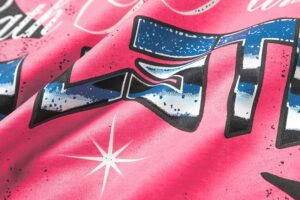 Close up of the Hellstar Path to Paradise T-shirt graphic featuring vibrant pink fabric and bold lettering designs.
