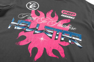 Hellstar Path to Paradise graphic tee detail with vintage washed black cotton and vibrant pink sun logo screen print.