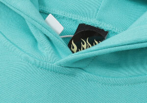 Close-up of the Hellstar Path to Paradise mint hoodie label detail featuring iconic flame branding inside the collar.