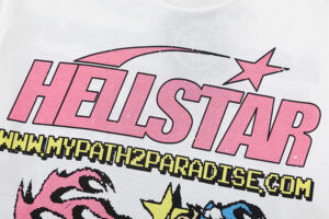 Close-up of the graphic on a white Hellstar Pixel T-Shirt featuring pink brand lettering and a star icon above the logo.