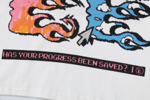 Close up of the Hellstar Pixel T-Shirt white fabric showing a vibrant retro pixelated graphic print with gaming text.