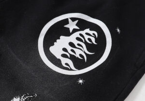 Close-up of the Hellstar Racer Vintage Black hoodie showing the white flame and star logo graphic on black fabric.