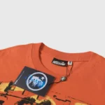 Close-up of the collar and brand tag detail on an orange Hellstar Rasta T-shirt made of 100% premium cotton fabric.