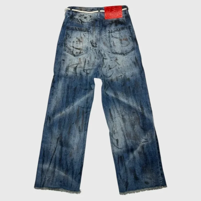 Back view of Hellstar Raw Edge Jeans featuring a washed denim finish with paint splatter details and a red logo patch