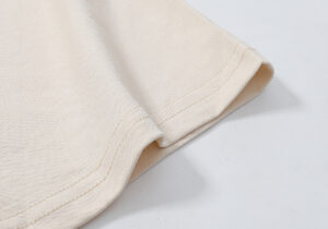 Close-up view showing the high-quality beige cotton fabric and stitching details of a Hellstar Records graphic T-shirt.
