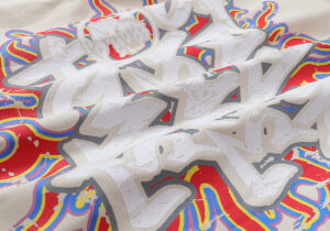 Close up view of the graphic screen print on a beige 100% cotton Hellstar Records vintage washed unisex T-shirt.